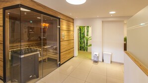 Una moderna zona de recepción con un panel de vidrio, mostrador de recepción, planta en la pared y un pequeño cesto de basura.