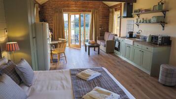 A cozy room with a bed, a dining table, and a kitchenette.