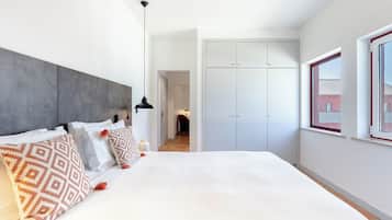 Un dormitorio moderno con una cama grande, un armario y una ventana con vistas.