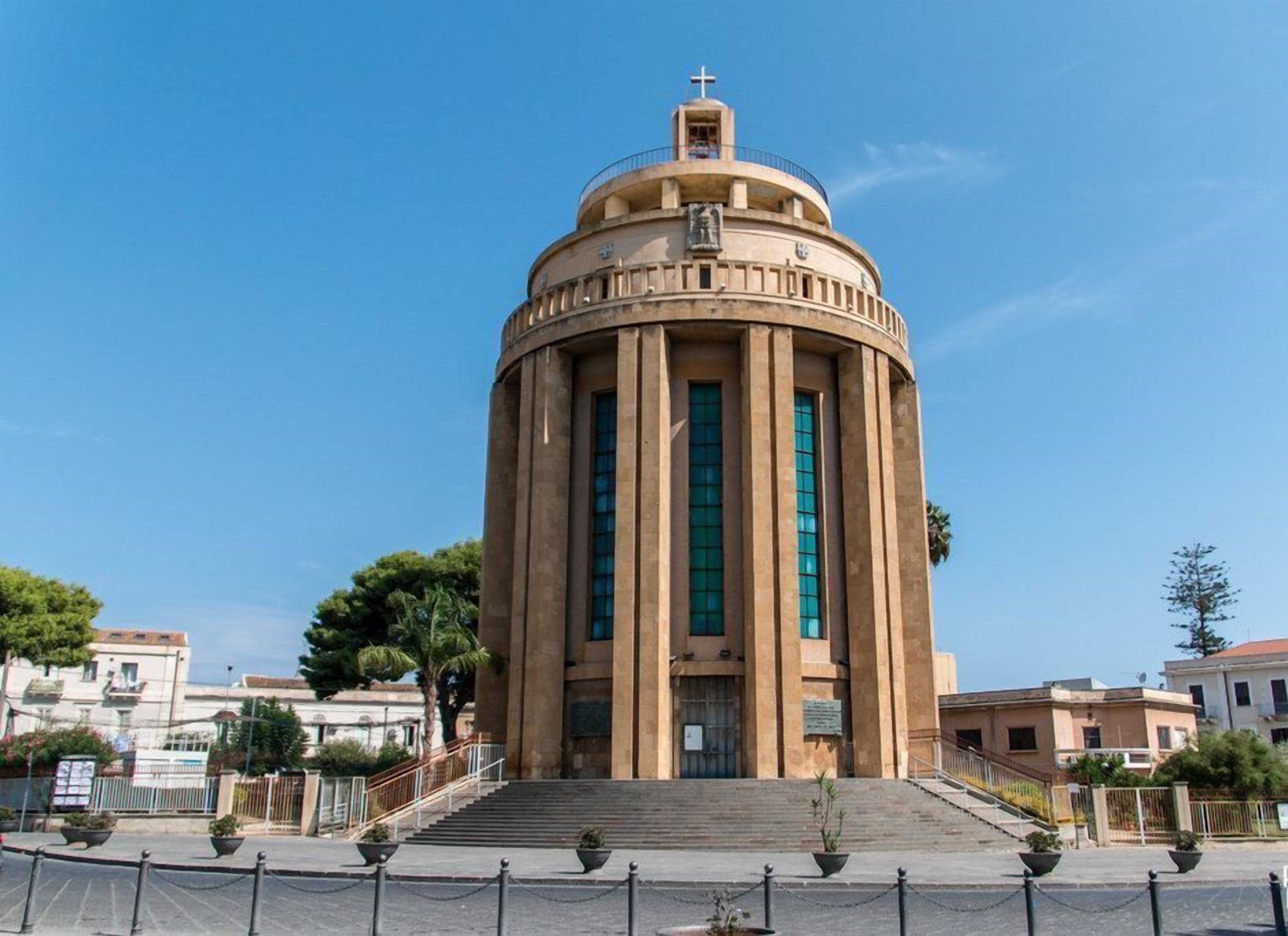 Un edificio independiente con una cúpula, una cruz en la parte superior y una escalera que conduce a la entrada.