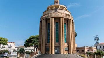 Un edificio independiente con una cúpula, una cruz en la parte superior y una escalera que conduce a la entrada.