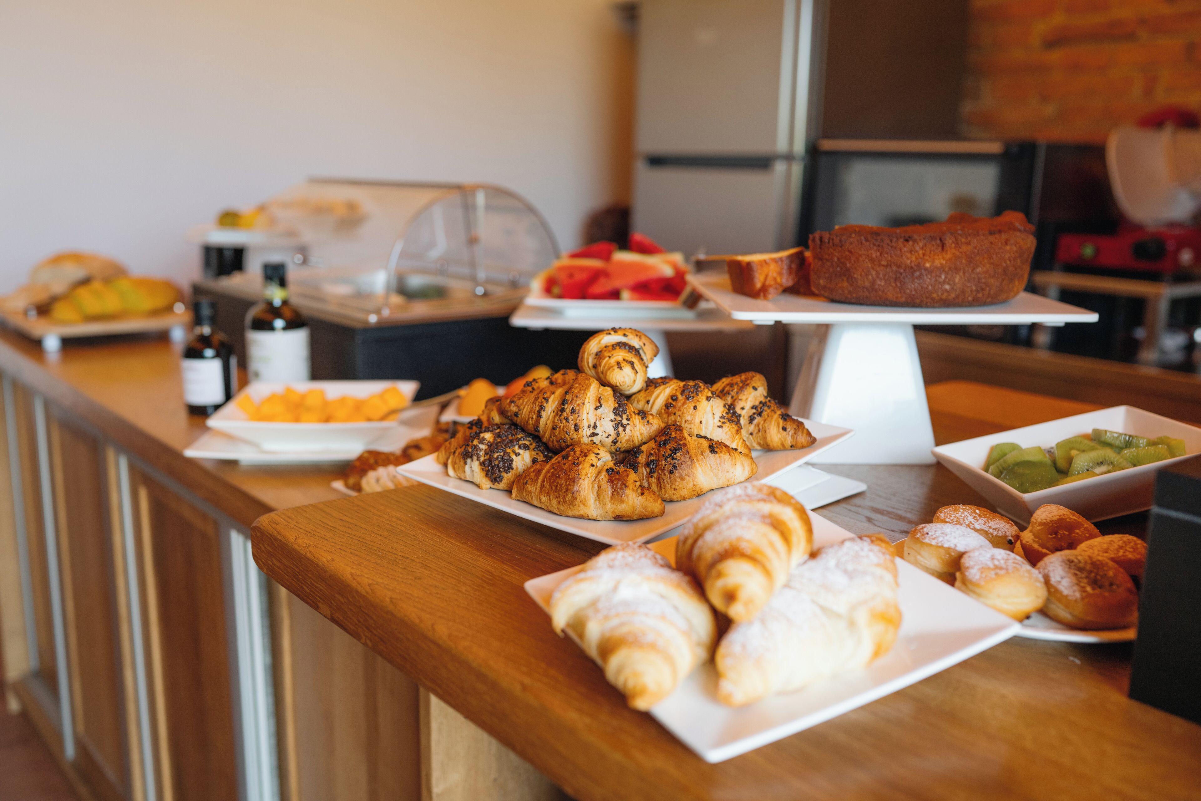 A buffet with various pastries and fruits.