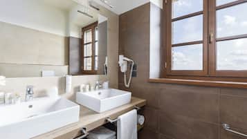 Un baño moderno con dos lavamanos, un espejo grande y una ventana con marcos marrones.