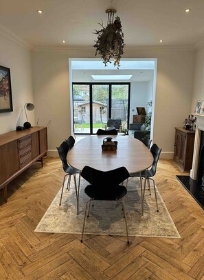 Enjoy meals and gatherings around the large round table, surrounded by comfortable seating and a warm fireplace.