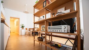 Una cucina moderna con scaffali in legno, una radio d'epoca e un'area pranzo con tavolo e sedie.