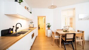 Una cucina moderna con un piano di lavoro in legno, forno integrato e zona pranzo con tavolo e sedie.