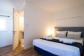 Une chambre à coucher avec un lit, des tables de chevet et une lampe fixée au mur.