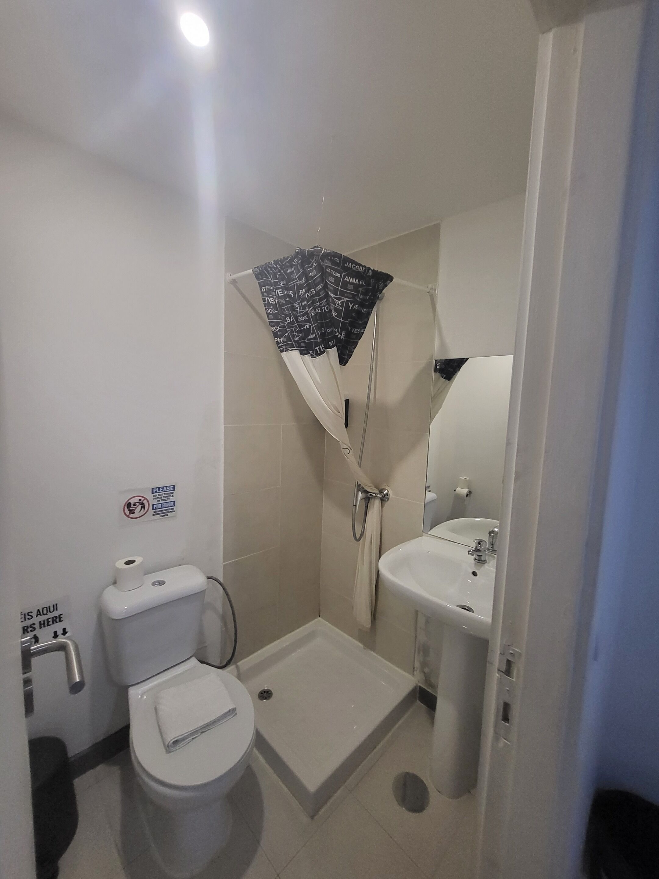 Ein kleines Badezimmer mit Toilette, Dusche und Waschbecken.