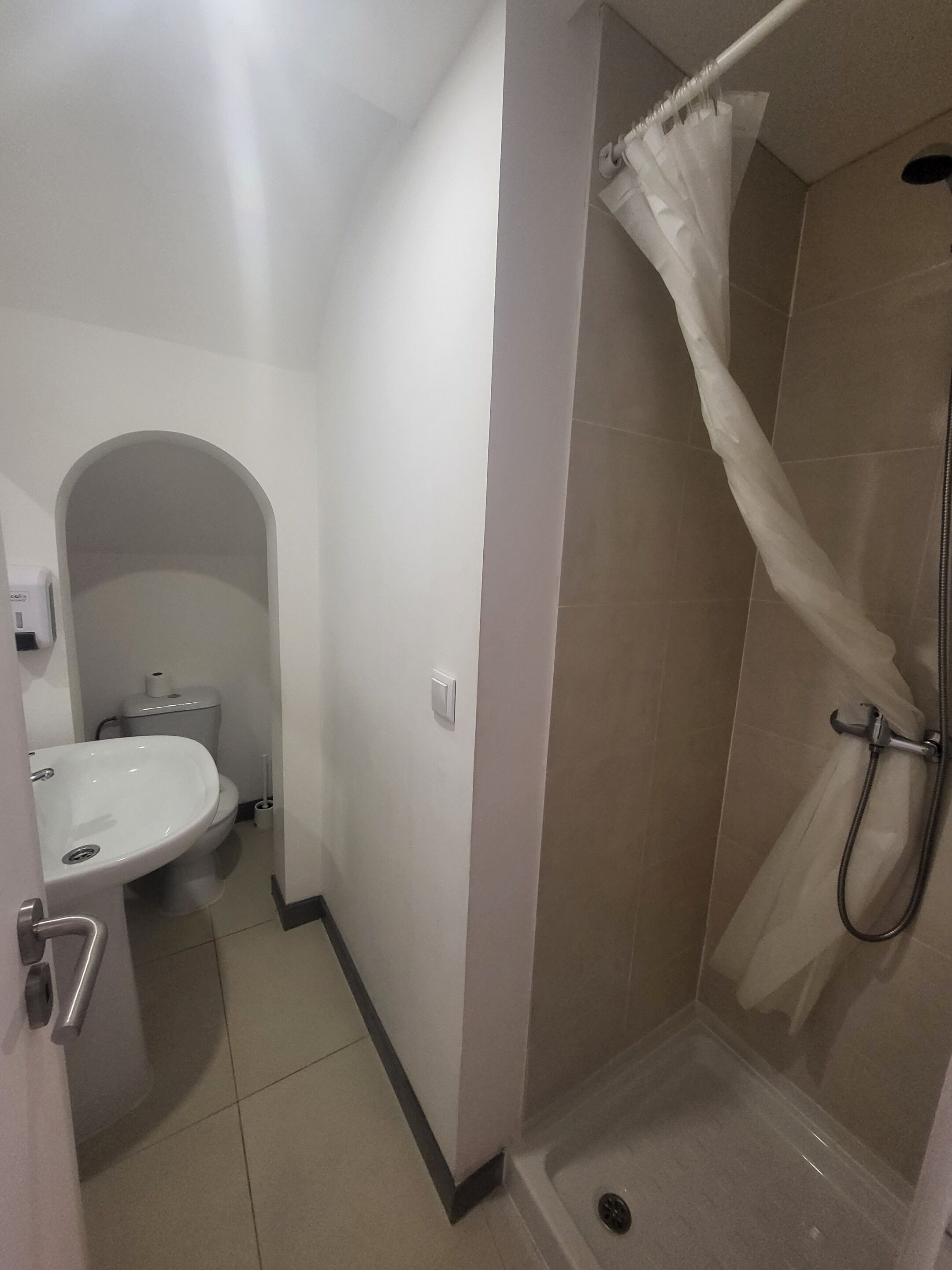 Un baño con ducha, inodoro y lavabo.