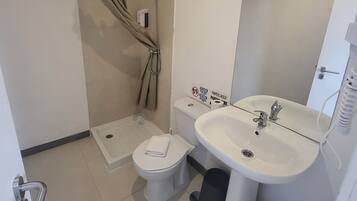 A compact bathroom with a shower, toilet, and sink.