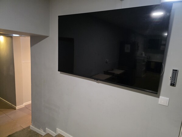 A room with a large window, a door, and a light switch on the wall.