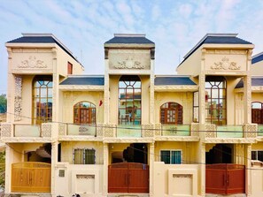 Un edificio de varios pisos con detalles arquitectónicos ornamentales, incluyendo columnas decorativas y balcones.