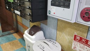 A fire extinguisher, a trash bin, and a fire alarm panel in a hotel room. - Grand Colbert NANBA 505, 605, 704 (Osaka)