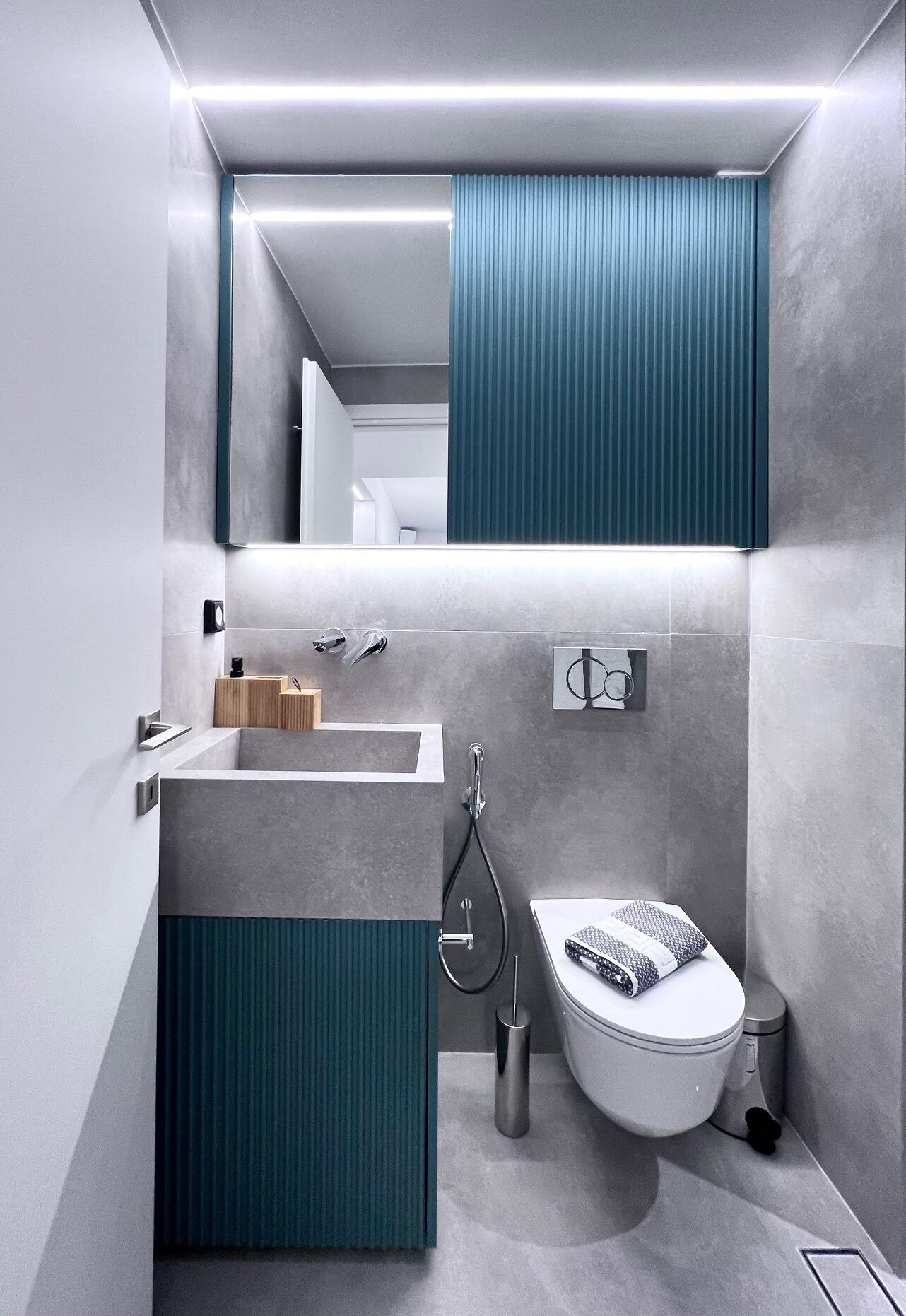 Ein modernes Badezimmer mit einem grauen Waschbecken, einer Toilette und einer Dusche.