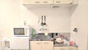 Une petite cuisine équipée comprenant un four à micro-ondes, un évier et des placards.