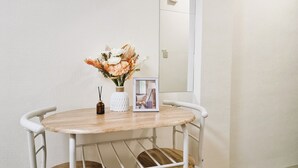 Une table ronde ornée d’un vase de fleurs et d’une photographie encadrée.