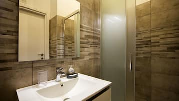 Deluxe kamer | Badkamer | Een douche, een regendouche, gratis toiletartikelen, een haardroger
