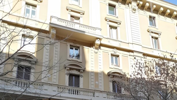 A historic building with a large arched entrance, multiple windows, and a sign indicating a restaurant. - Residenza Tupini S.Pietro Suites (Rome)