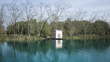 Un edificio pequeño y aislado sobre un lago rodeado de árboles.