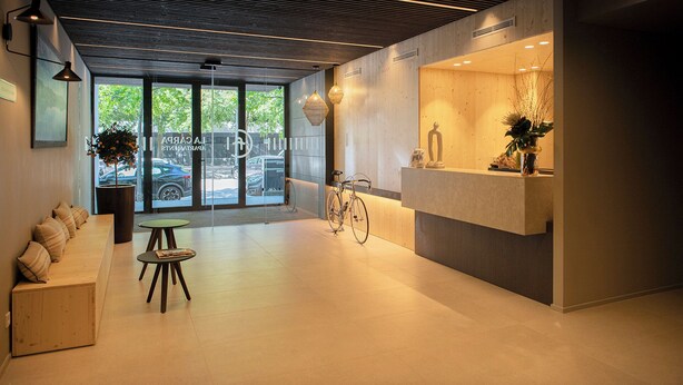 Een moderne receptie met een houten bank, een receptiebalie en een fiets.