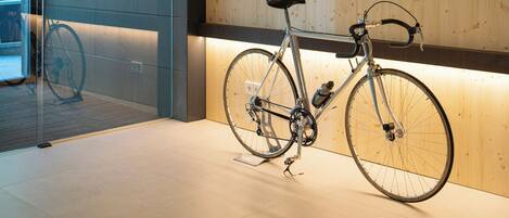 Een modern interieur met een aan de muur bevestigde fiets, houten lambrisering en een glazen deur naar buiten.