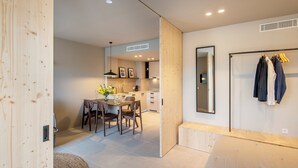 Een modern interieur met een eethoek, keuken en een kledingrek.