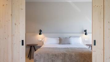 A modern bedroom with a large bed, wooden paneling, and two bedside lamps.