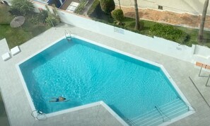 Ein rechteckiger Swimmingpool mit einer Leiter und einer darin schwimmenden Person.