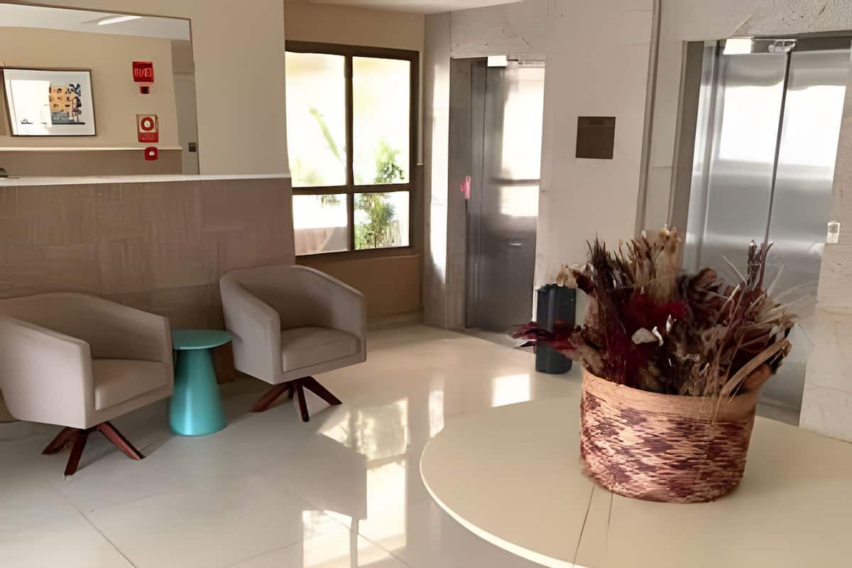 Un vestíbulo moderno con dos sofás, una mesa redonda y una planta decorativa.