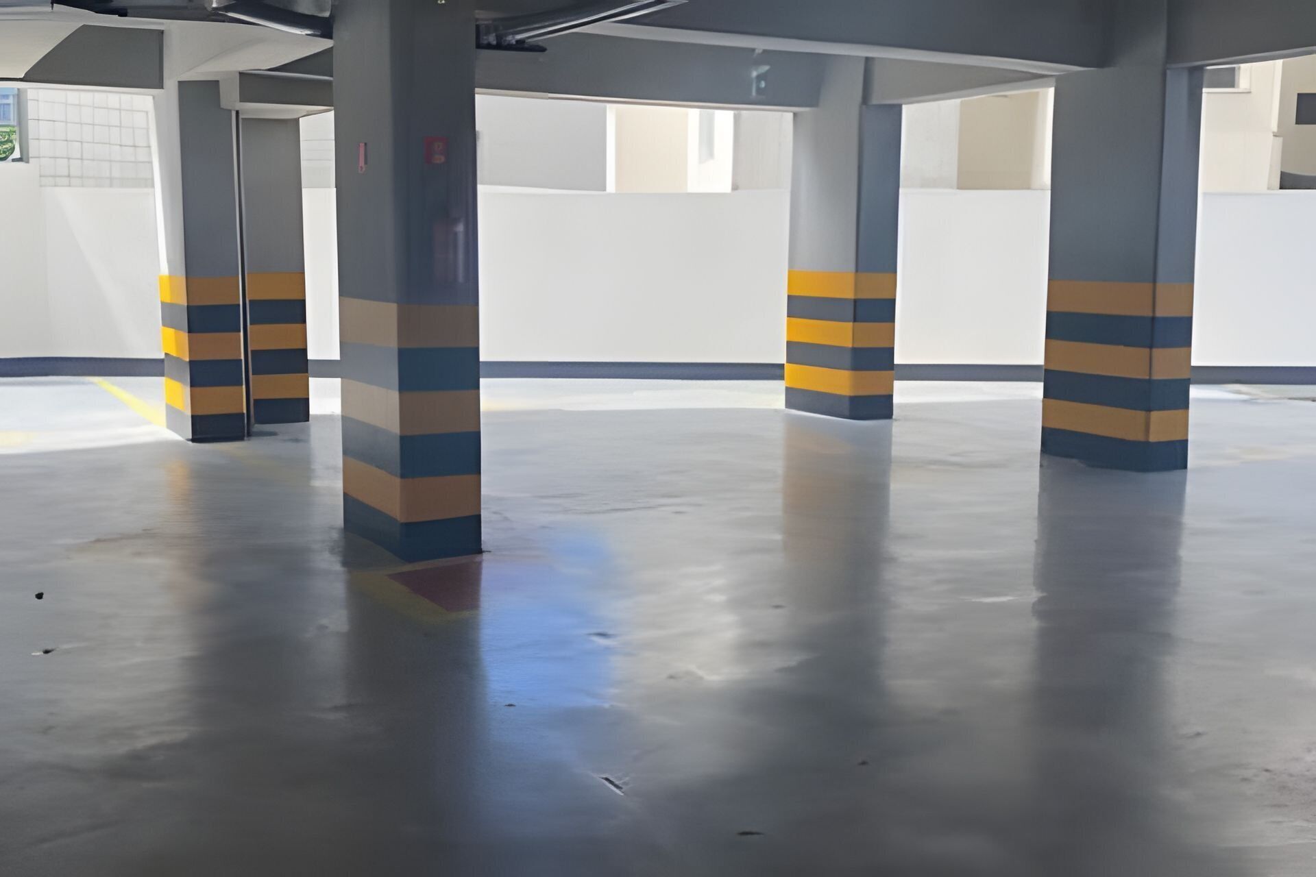 A parking garage with striped pillars and a clean, reflective floor.