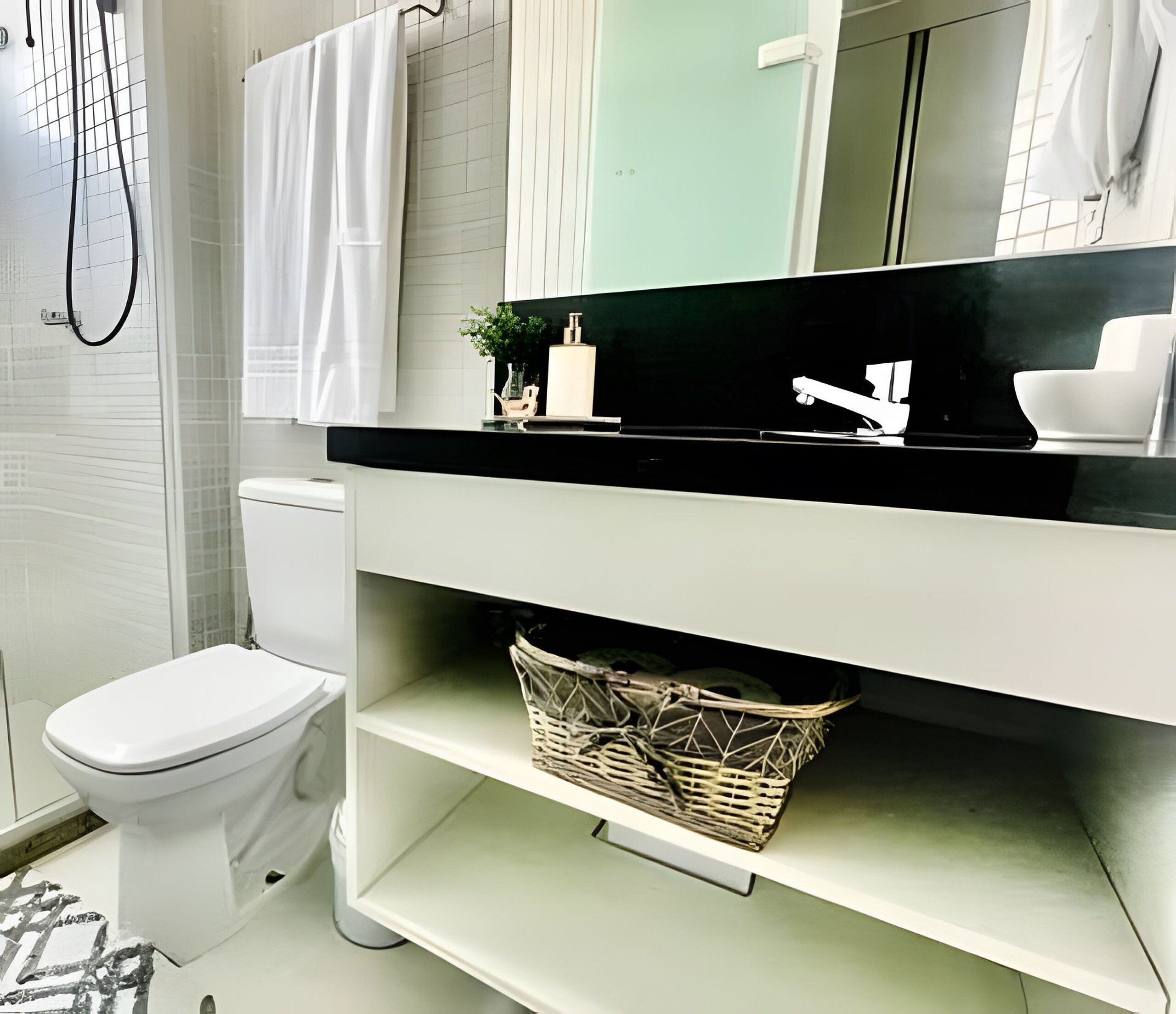 A modern bathroom with a white toilet, a black countertop, a mirror, and a wicker basket.