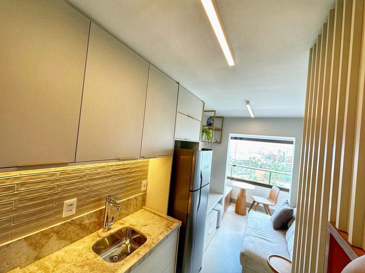 Eine moderne Küche mit integriertem Spülbecken, einem Edelstahl-Kühlschrank und einem Fenster mit Blick auf die Stadt.