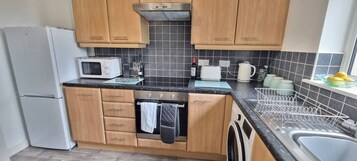 Apartamento Confort | Cocina privada | Frigorífico grande, microondas, horno y placa de cocina