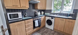 Apartamento Confort | Cocina privada | Frigorífico grande, microondas, horno y placa de cocina