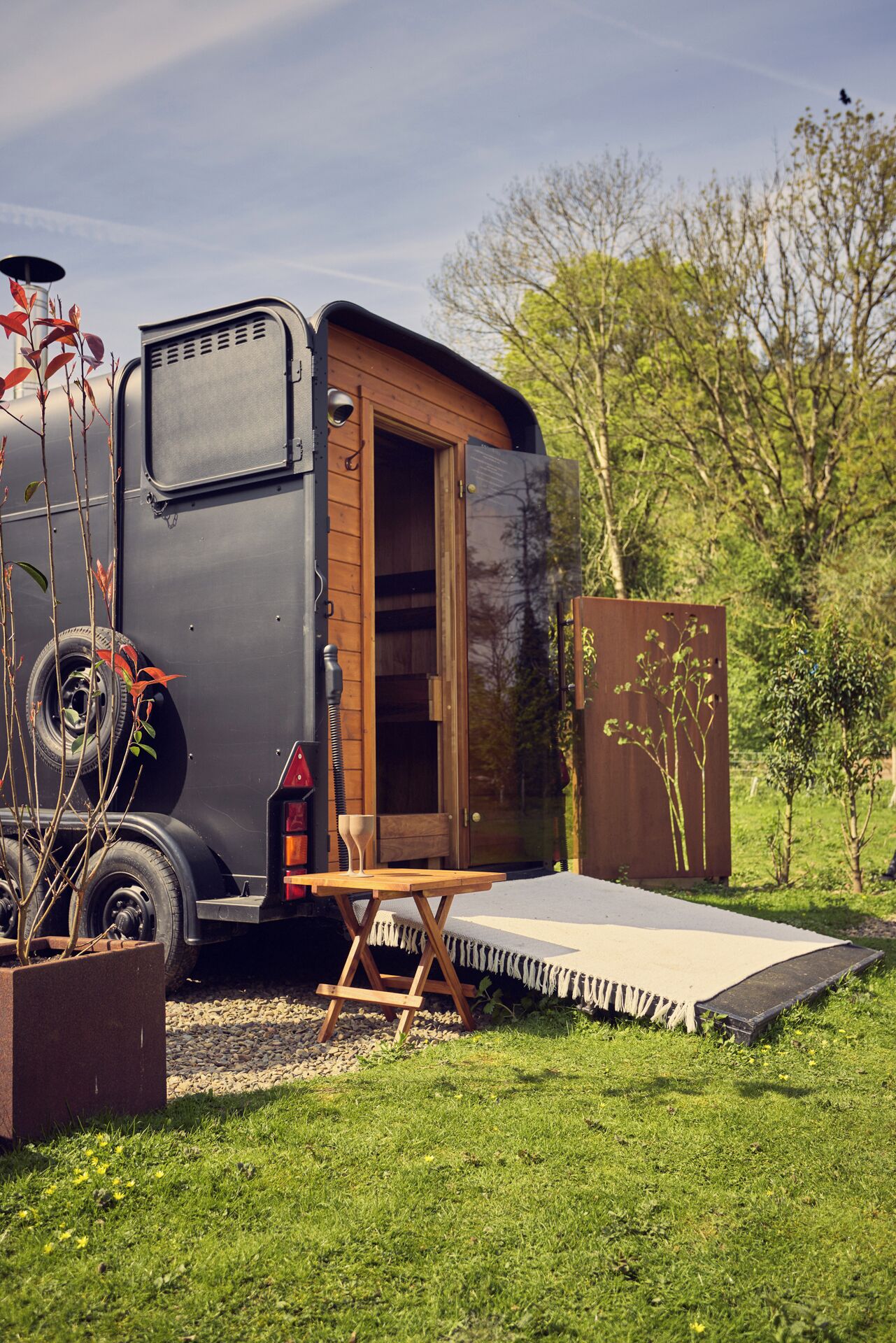 A mobile home with a wooden door, a small table, and a bench.
