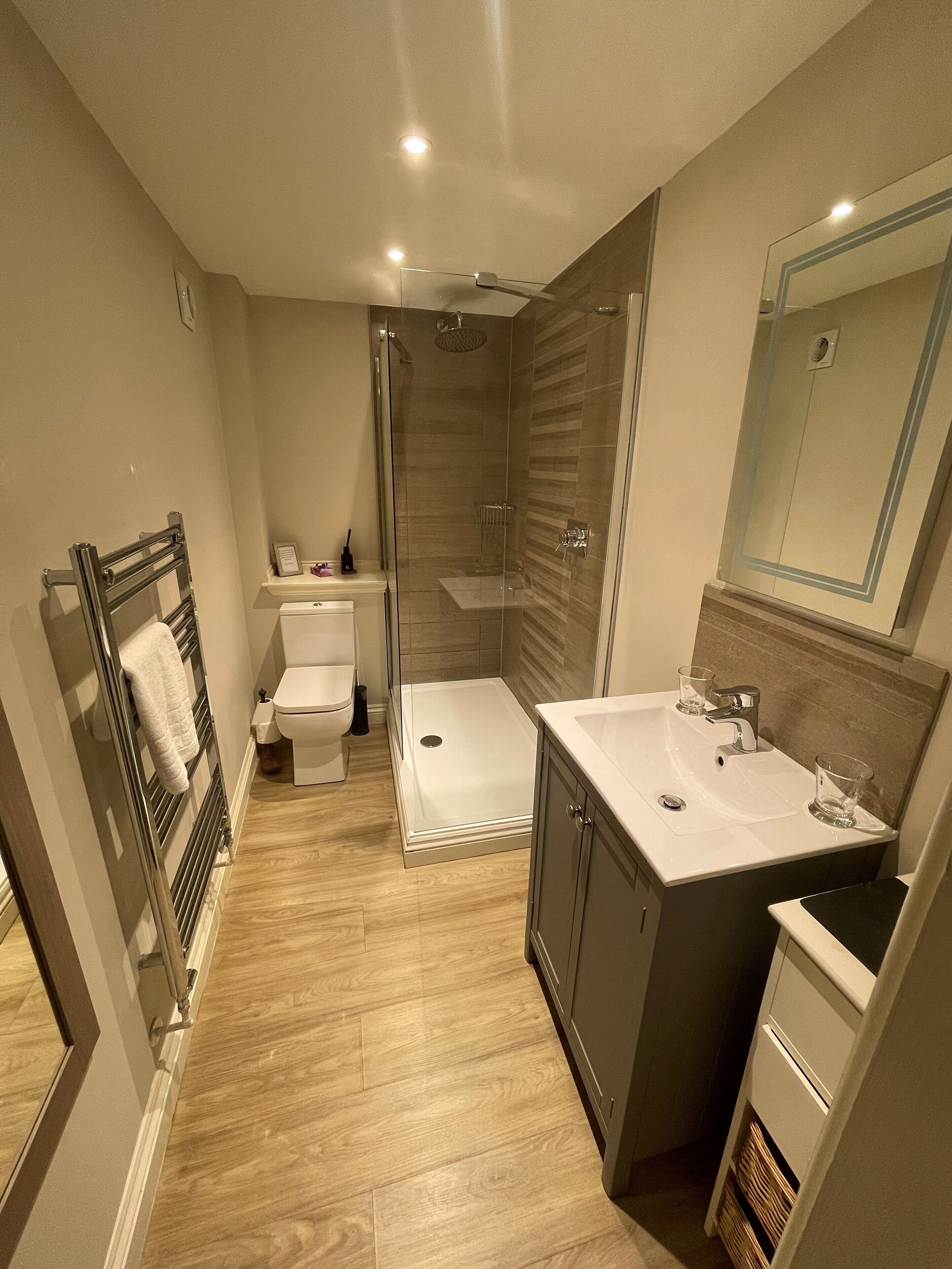A compact bathroom with a shower, toilet, and sink.
