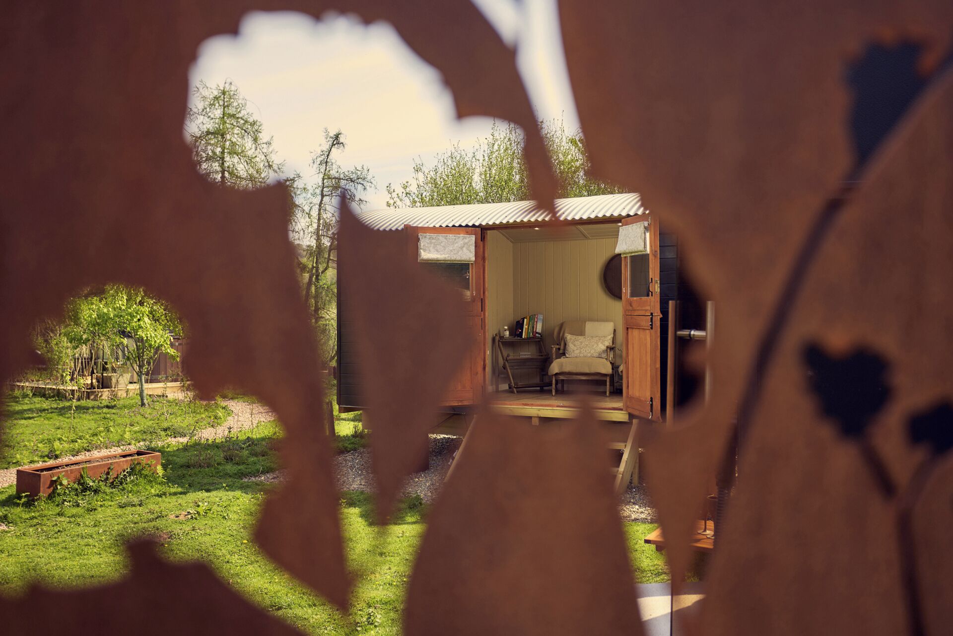 A cozy cabin with a wooden exterior, a small porch, and a view of the surrounding greenery.