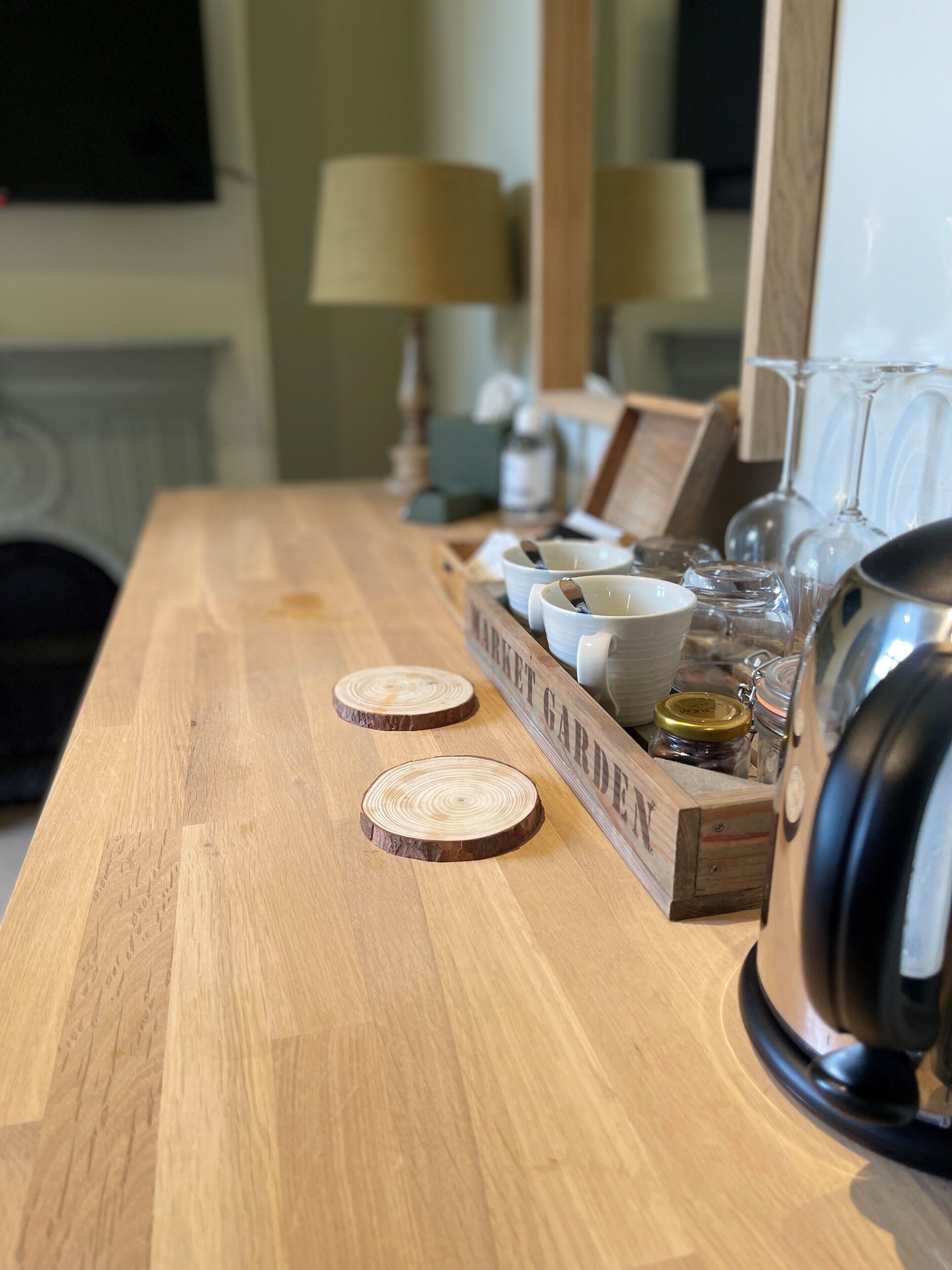 A wooden table with a wooden box labeled "MARKET GARDEN" containing bowls, glasses, and jars.
