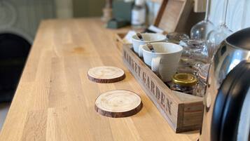 A wooden table with a wooden box labeled "MARKET GARDEN" containing bowls, glasses, and jars.