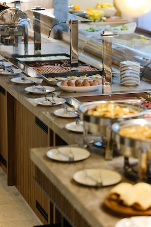 A buffet setup with various food items and utensils. - Hotel Vema (Visoko)
