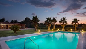 A swimming pool with a clear view of the sky, palm trees, and a building with outdoor seating. - Malibu Grand Royale - Luxury Group Villa with Pool (Vir)