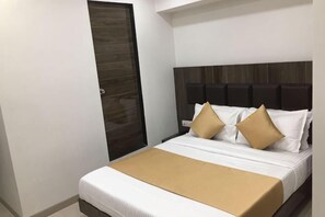 Une chambre dâhĂŽtel avec un lit, une porte en bois et une tĂȘte de lit.
