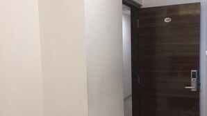 Una puerta cerrada con una cerradura electrónica y una placa con número.