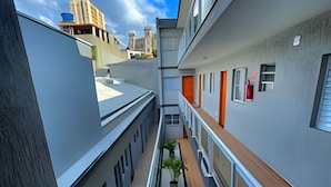 Un edificio moderno con un cortile interno, balconi e vista sulla città.