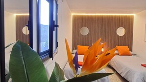 A modern hotel room with two beds, a large window, and a decorative plant. - Morera Blanca (Canet de Fals)