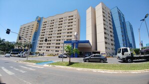A large hotel building with multiple floors, a prominent entrance, and a parking area. - Golden Dolphin 01 Quarto - Caldas Novas -GO (Caldas Novas)