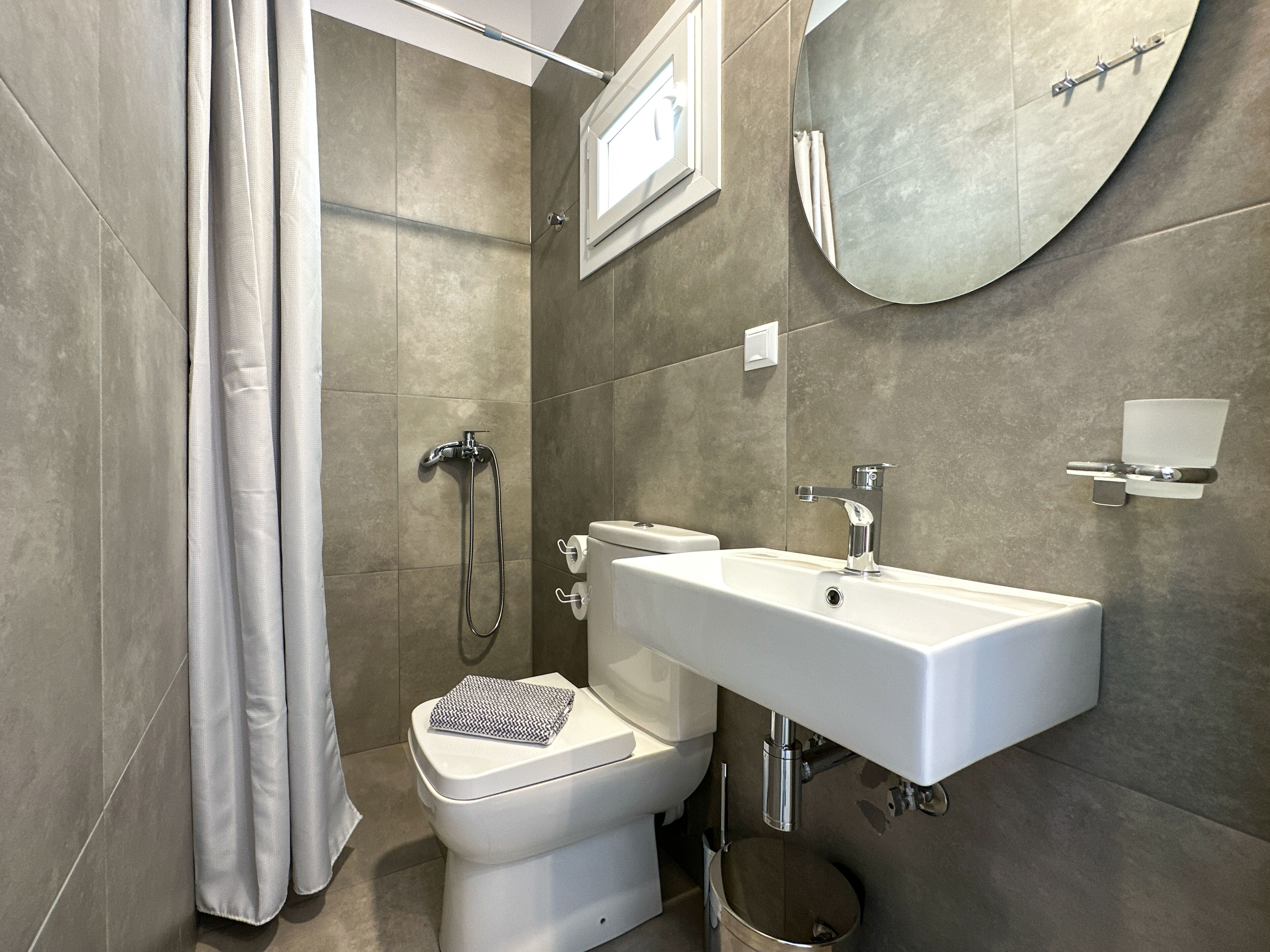 A modern bathroom with a toilet, bidet, and sink.