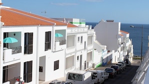 A coastal street with white buildings, a clear blue sky, and the sea in the background. - Albufeira 2 - Beach & Old Town (Albufeira)