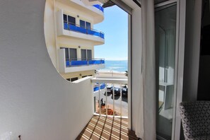 Enjoy breathtaking ocean views from this spacious balcony with a glass door and metal railing.