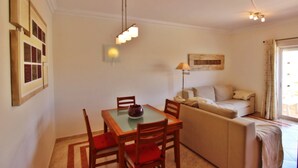 Un coin repas avec une table et des chaises, un canapé et une lampe.